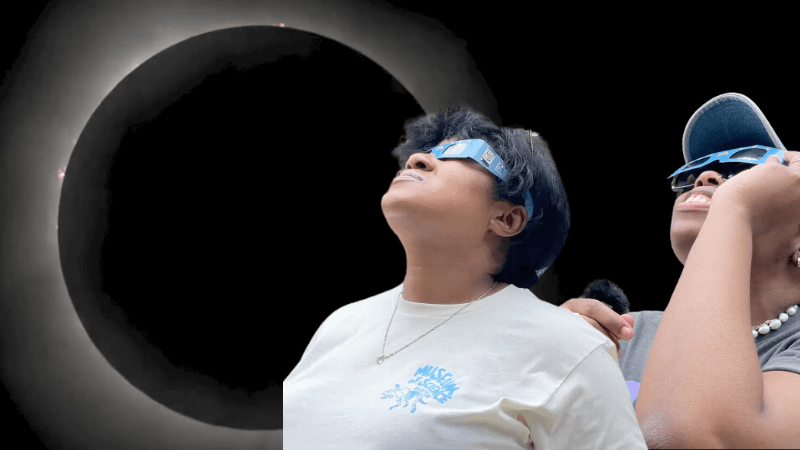 Titi and Zakiya looking at an eclipse with eclipse glasses