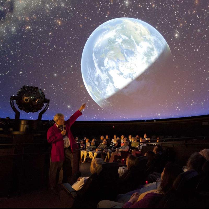 A Museum Educator presenting a live planetarium show.