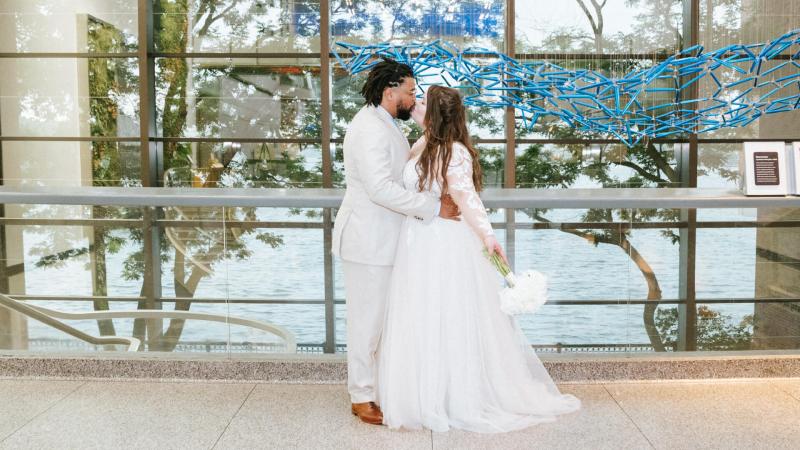 A couple embracing on their wedding day in the Museum lobby.