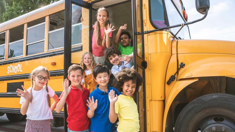 A group of kids getting on a bus for a field trip.