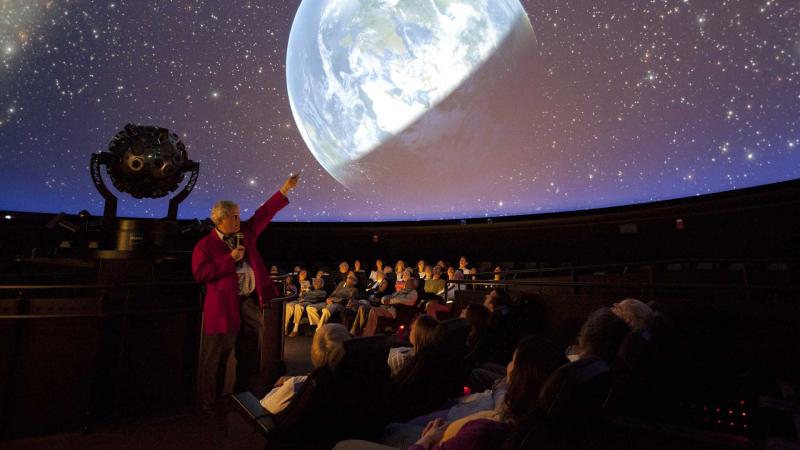 A Museum Educator presenting a live planetarium show.