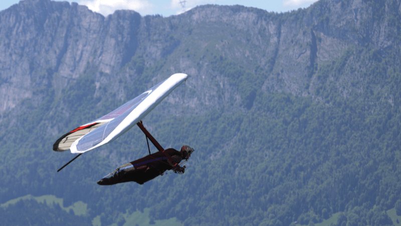 A person paraglides near some mountains