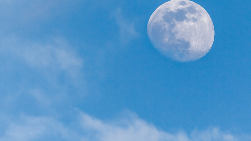 The moon in a blue sky during the day