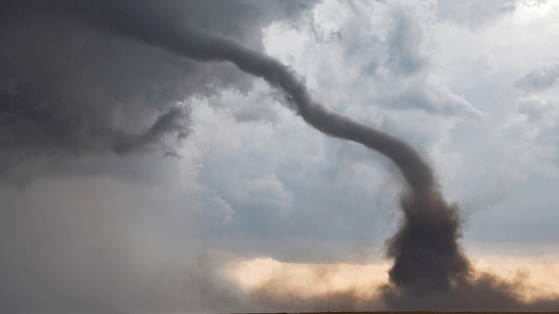 A tornado touches down from a dark cloud