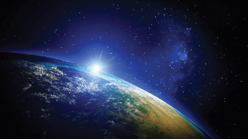 The Sun rises over the horizon of the Earth as viewed from space