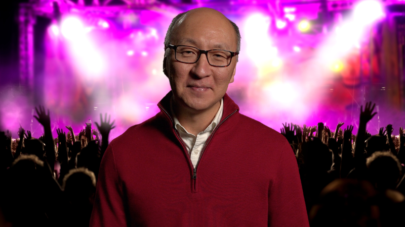 Insoo Hyun in front of a concert with pink lights