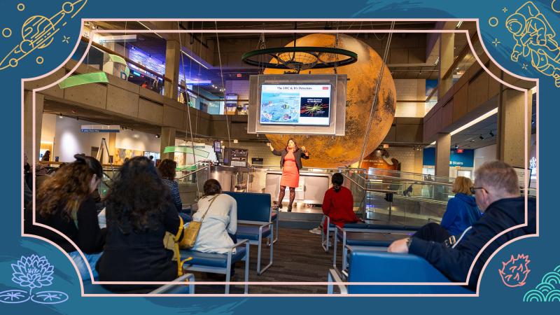 A group of visitors watching a Scientist speak at the CS&T stage.
