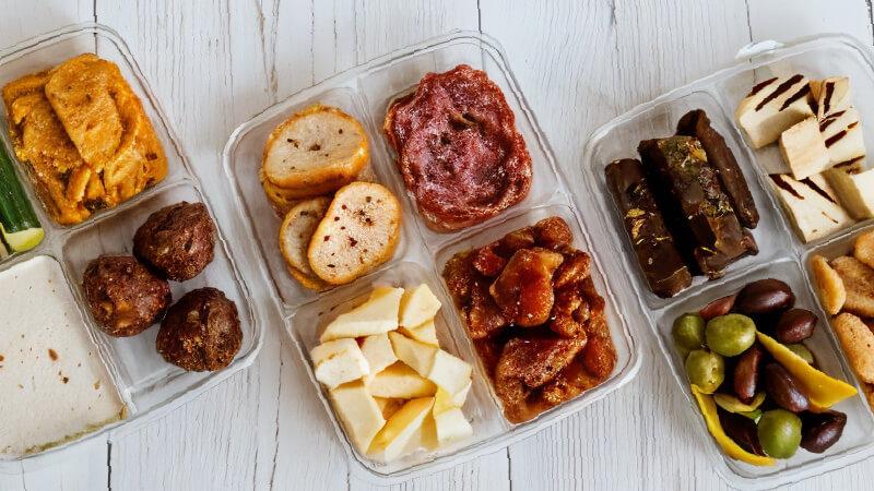 Grab and go boxes of snacks including crackers, cheese, and various spreads.