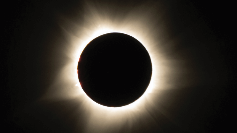 The sun behind the moon with a yellow coronoa