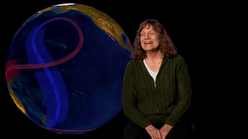 Amy Bower smiling with a picture of the Earth and it's ocean currents behind her.