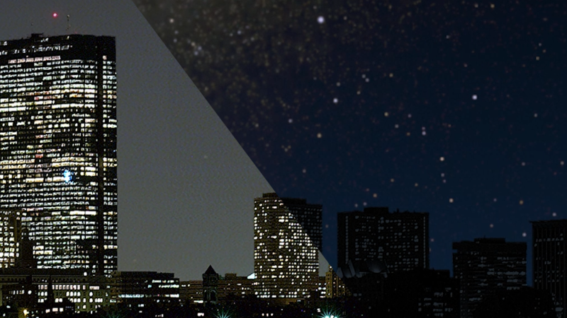 Image of city with lights on in buildings on the left and lights off in buildings on the right 