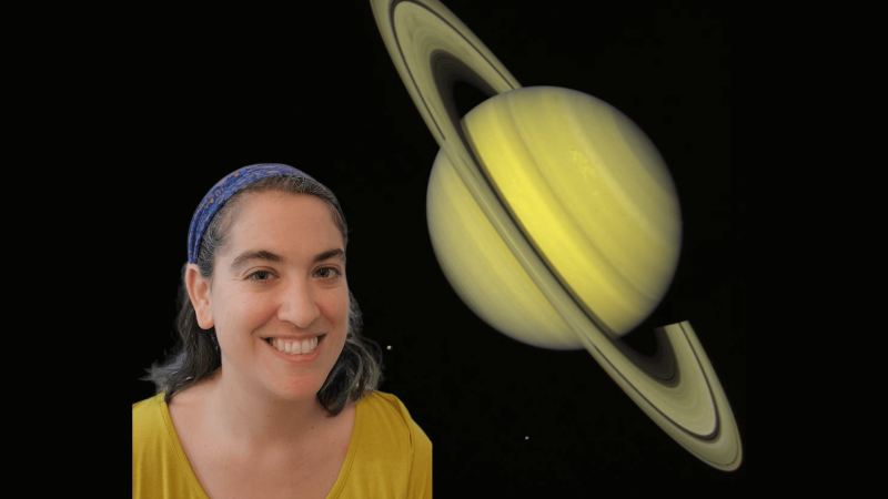 Talia smiling in front of a picture of the planet Saturn. 
