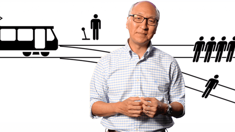 Insoo Hyun in front of a diagram of the trolley problem