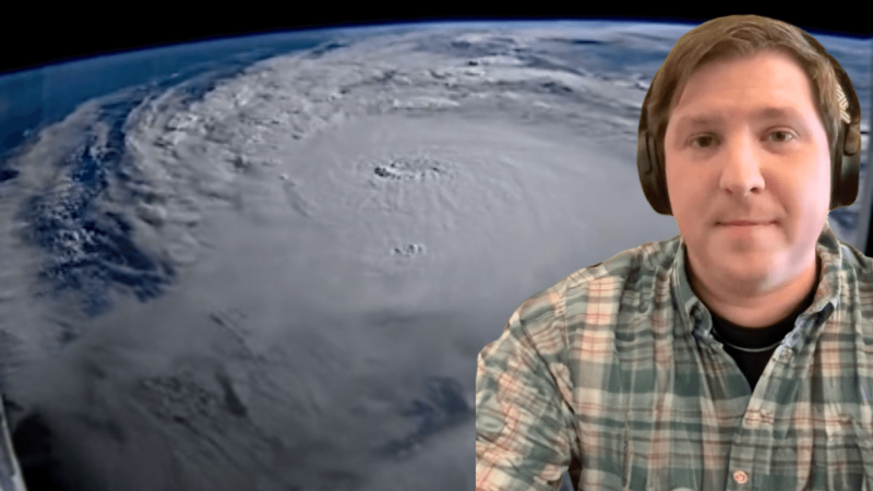 Dr. Daniel Gilford in front of a satellite image of Hurricane Milton