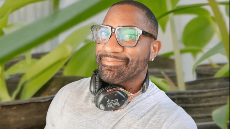  Maynard Okereke in front of an image of potted seedlings