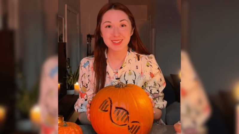 Alex Dainis with a pumpkin carved into a DNA strand