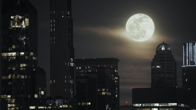 A full moon over a city skyline
