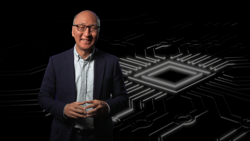 Insoo Hyun in front of an image of a computer chip