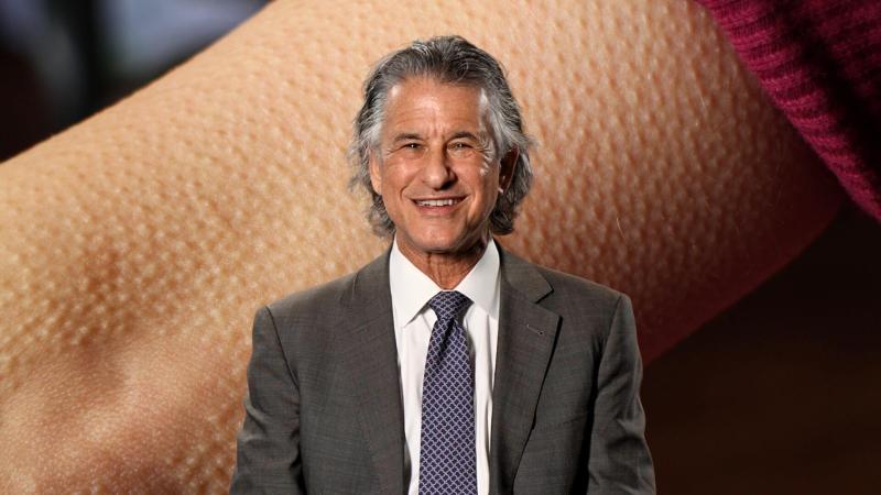Dr. Daniel Levitin in front of an image of an arm with goosebumps