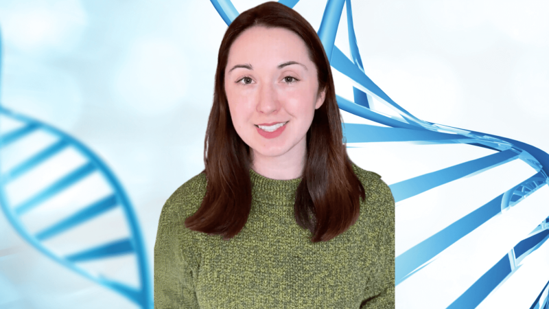 Alex Dainis in front of an illustration of DNA helixes