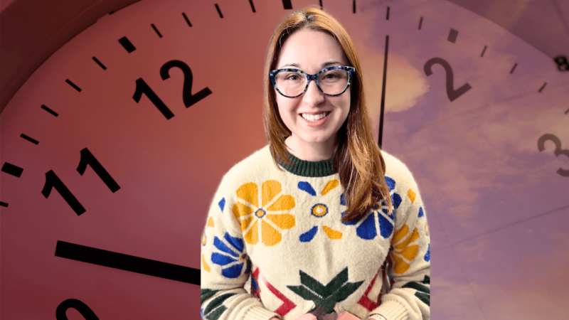 Alex Dainis in front of an image of a clock