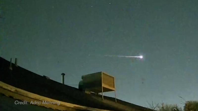 A meteor flies over a house