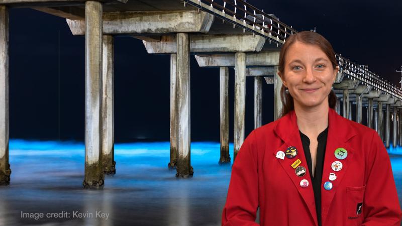 Museum Educator Sloane in front of bioluminescent plankton under a boardwalk