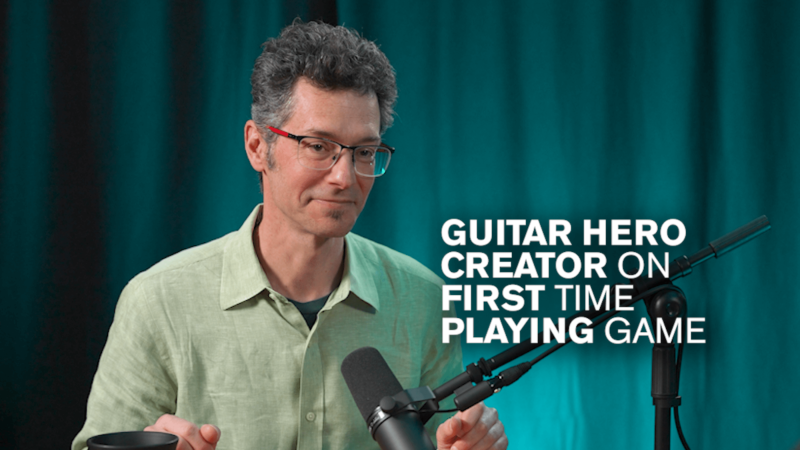 Eran Ergozy in front of a teal backdrop with white text reading "Guitar Hero Creator on First Time Playing Game"
