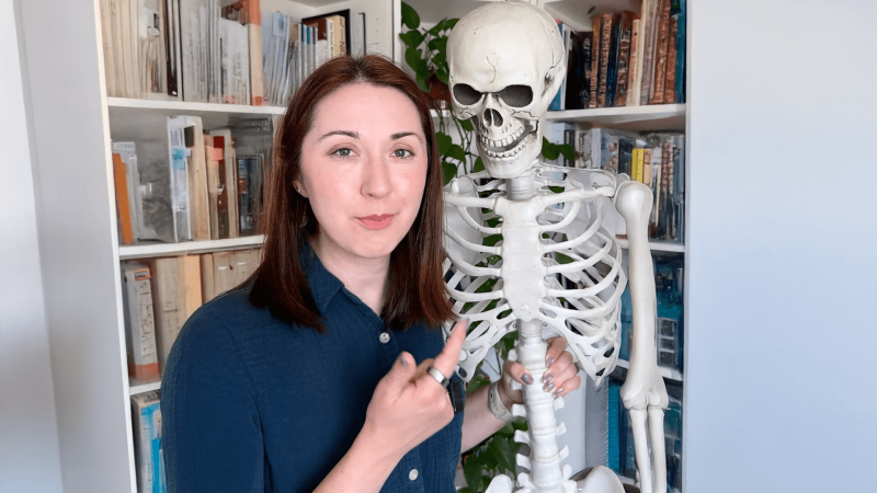 Alex Dainis pointing to a skeleton