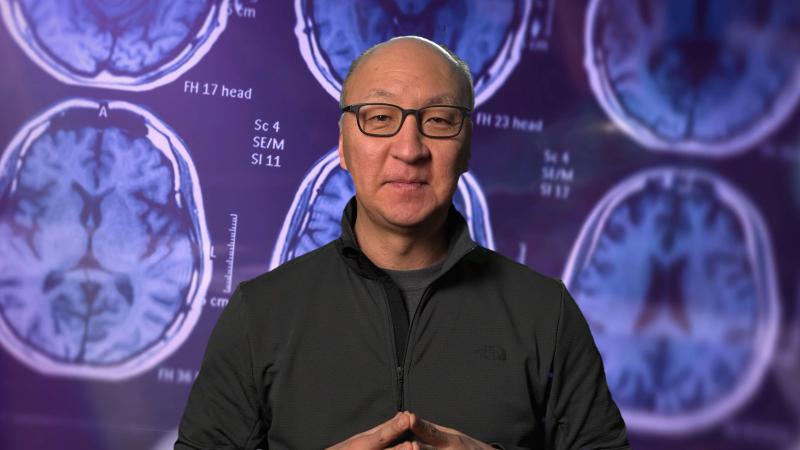 Insoo Hyun in front of brain scans.