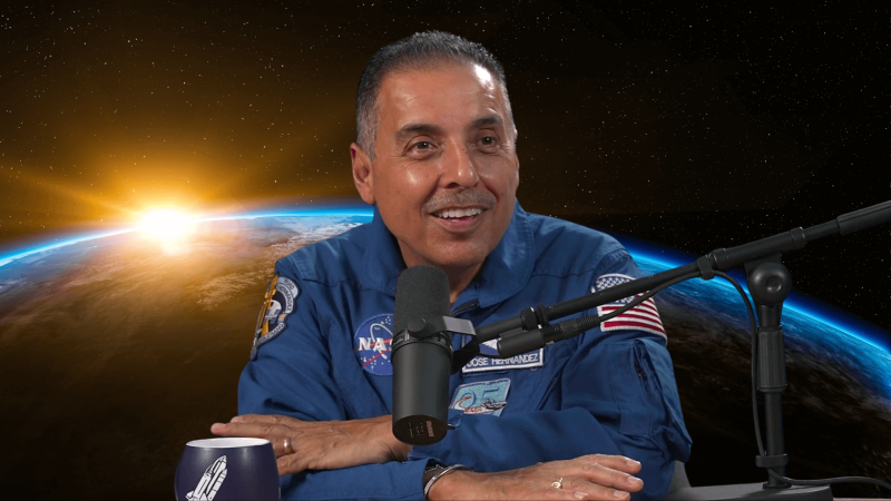 Jose Hernandez with a microphone in front of the sun rising over the globe.