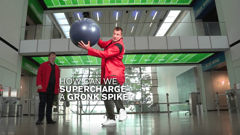 Rob Gronkowski spikes a football off an exercise ball with white text reading "How Can We Supercharge a Gronk Spike?"
