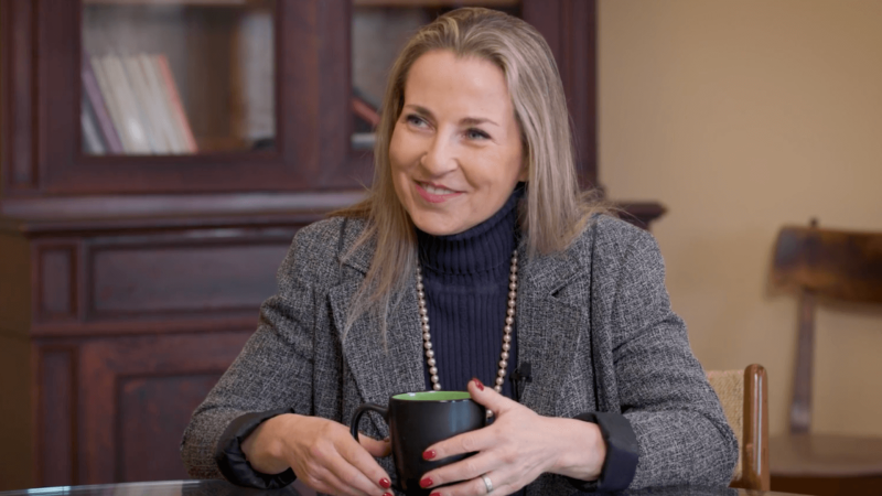 Vardit Ravitsky smiles while holding a coffee mug in a home setting