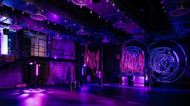 Interactive artwork projected all throughout a warehouse space.