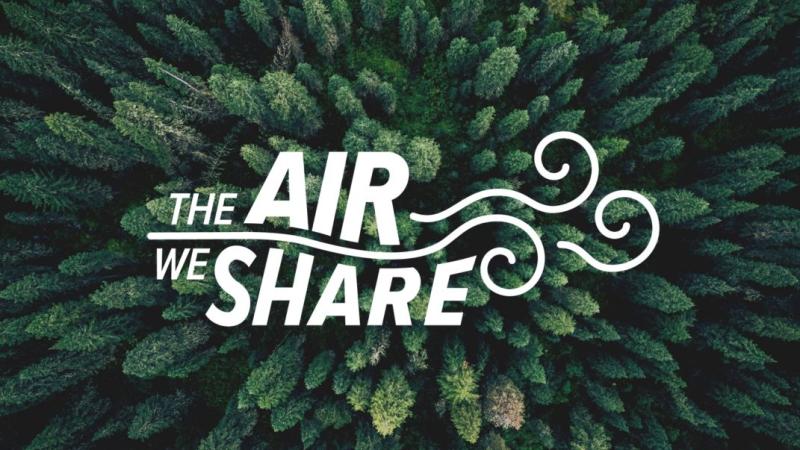 The Air We Share logo over a view of evergreen treetops