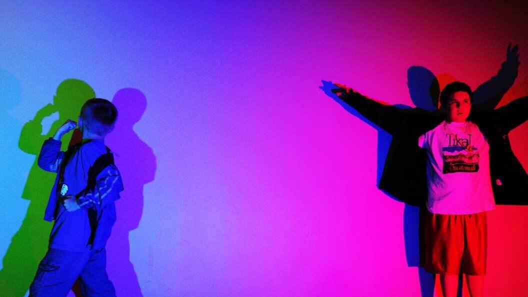 Kids playing with different colored lights in the Light Hosue exhibit.