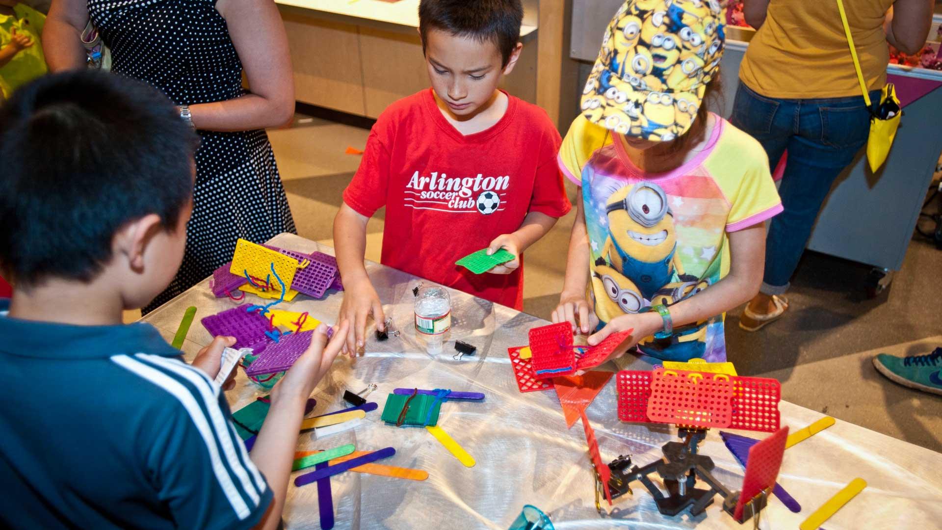 Three children working on an engineering challenge.