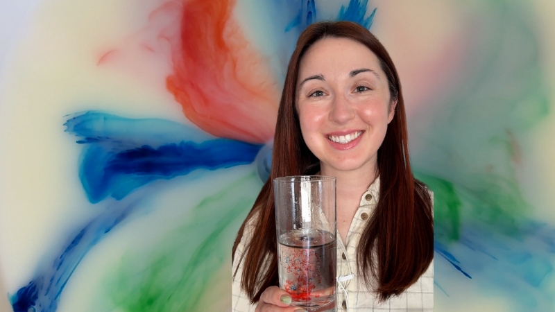 Alex Dainis holding up a glass with a tie-dye background