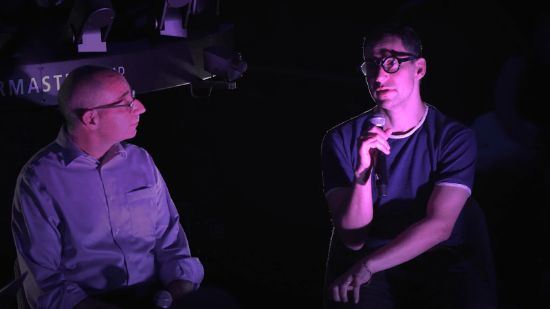 Jack Antonoff and MIT Professor David Kaiser with a purple light on them. 
