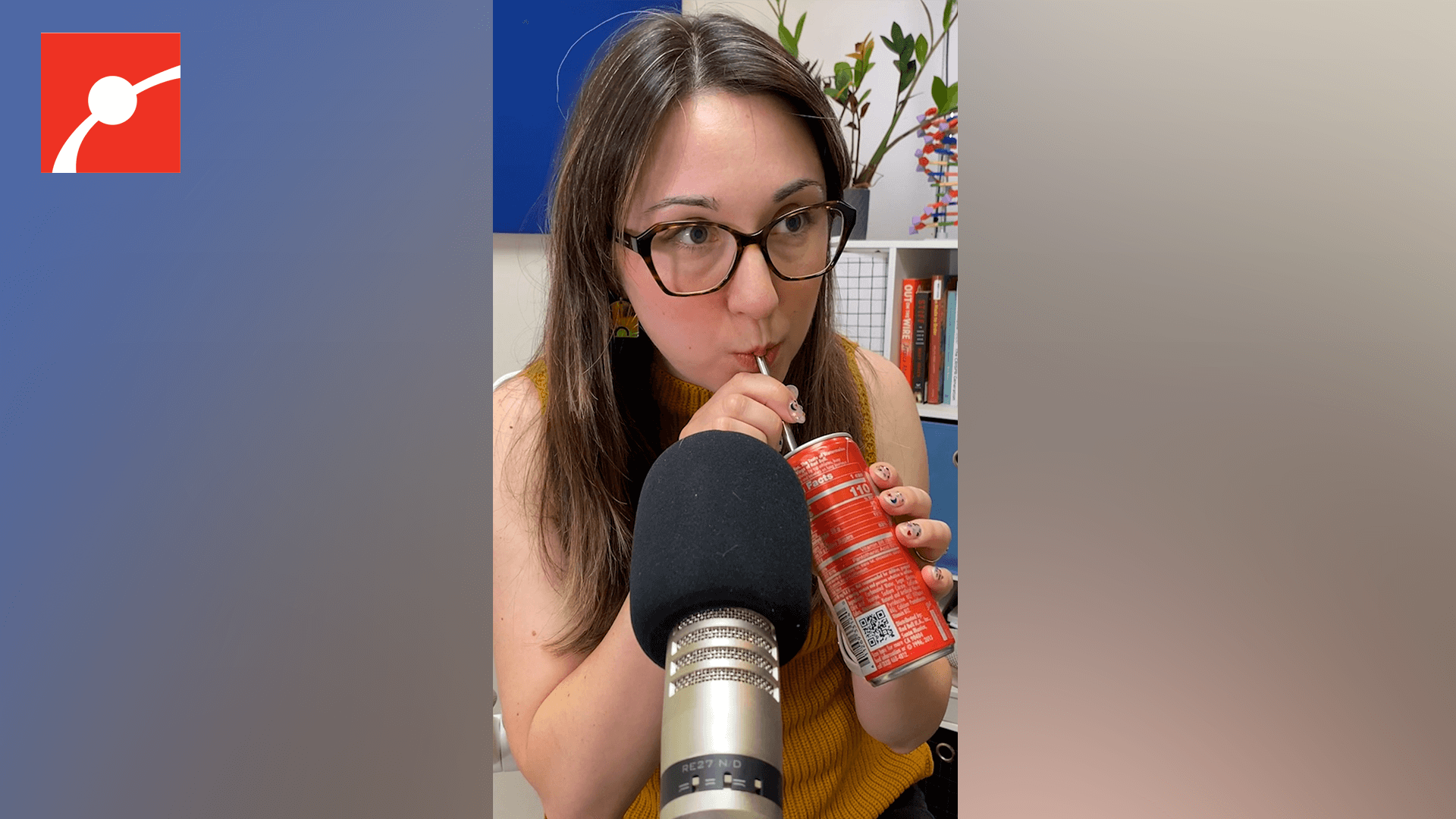 Alex Dainis drinking out of a soda can in front of a microphone.