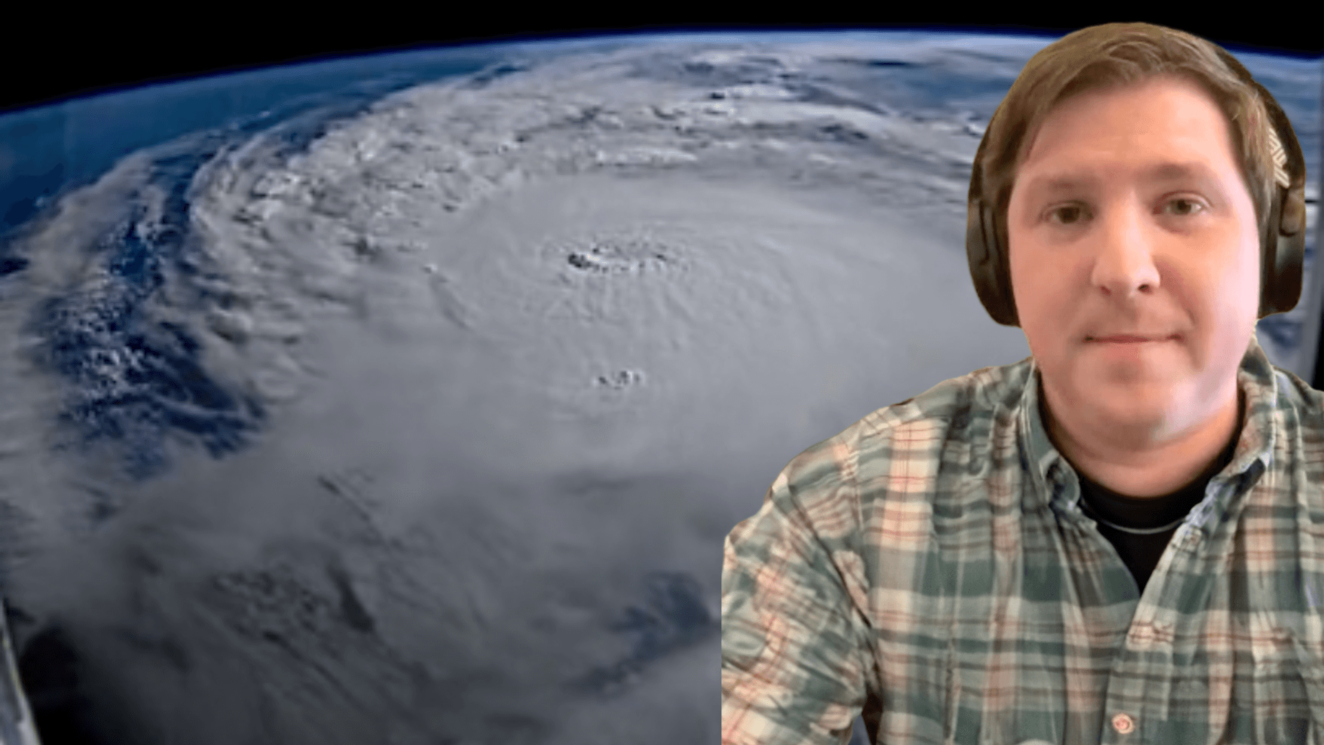 Dr. Daniel Gilford in front of a satellite image of Hurricane Milton