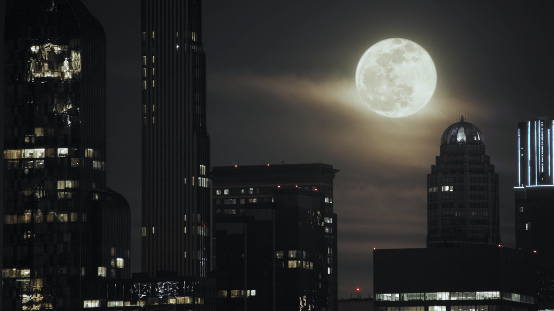 A full moon over a city skyline