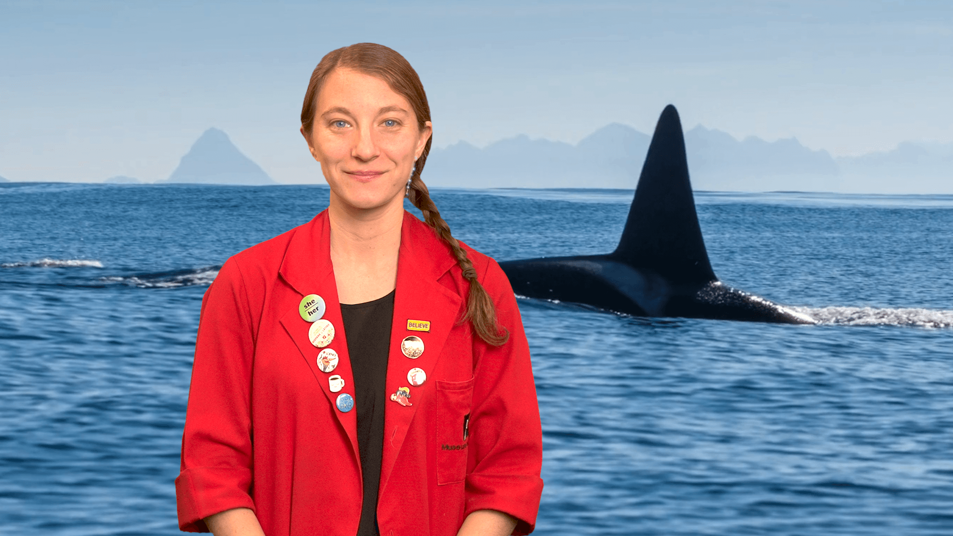 Museum Educator Sloane in front of an image of a whale