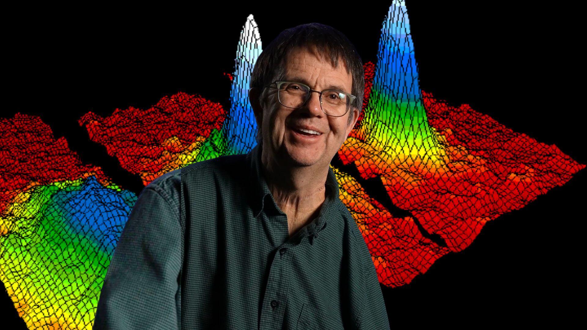 Dr. Eric Cornell in front of an image of a Bose-Einstein condensate