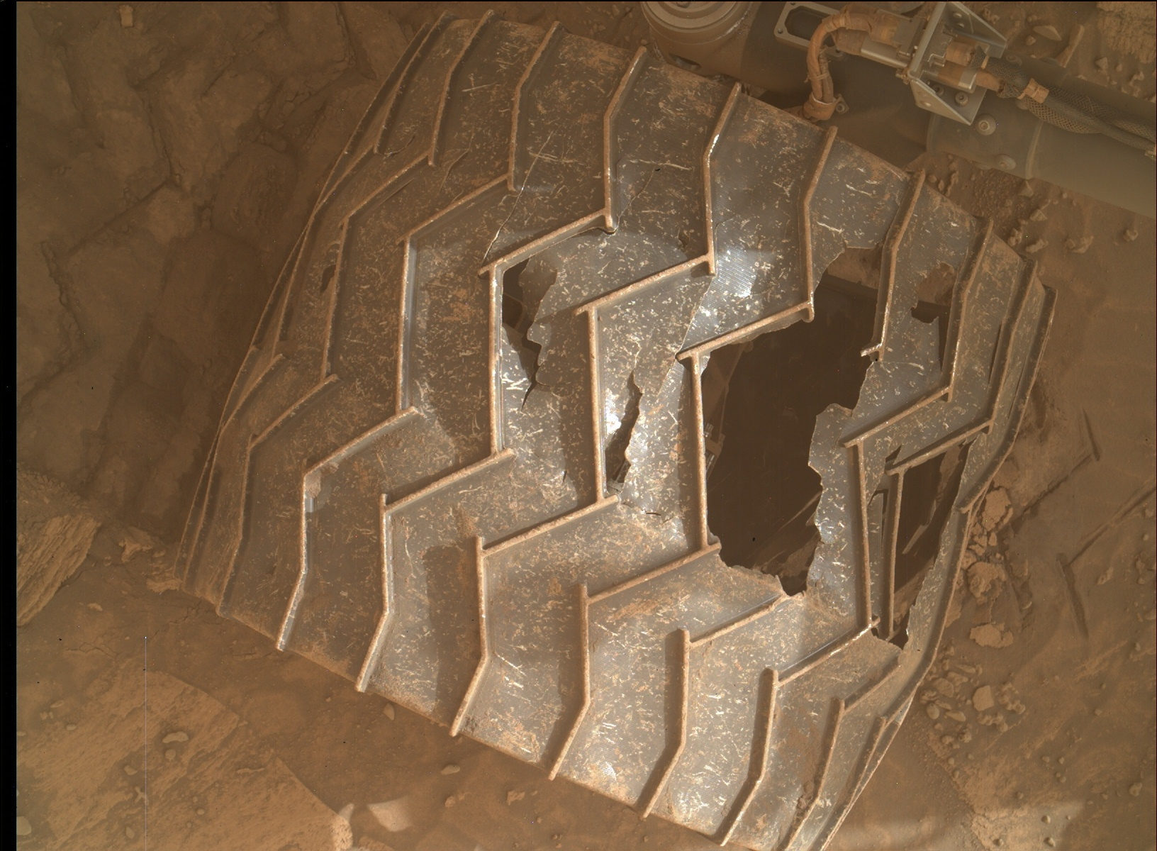 An image of one of Curiosity’s wheels showing accumulated damage. Credit; NASA/JPL-Caltech/MSSS