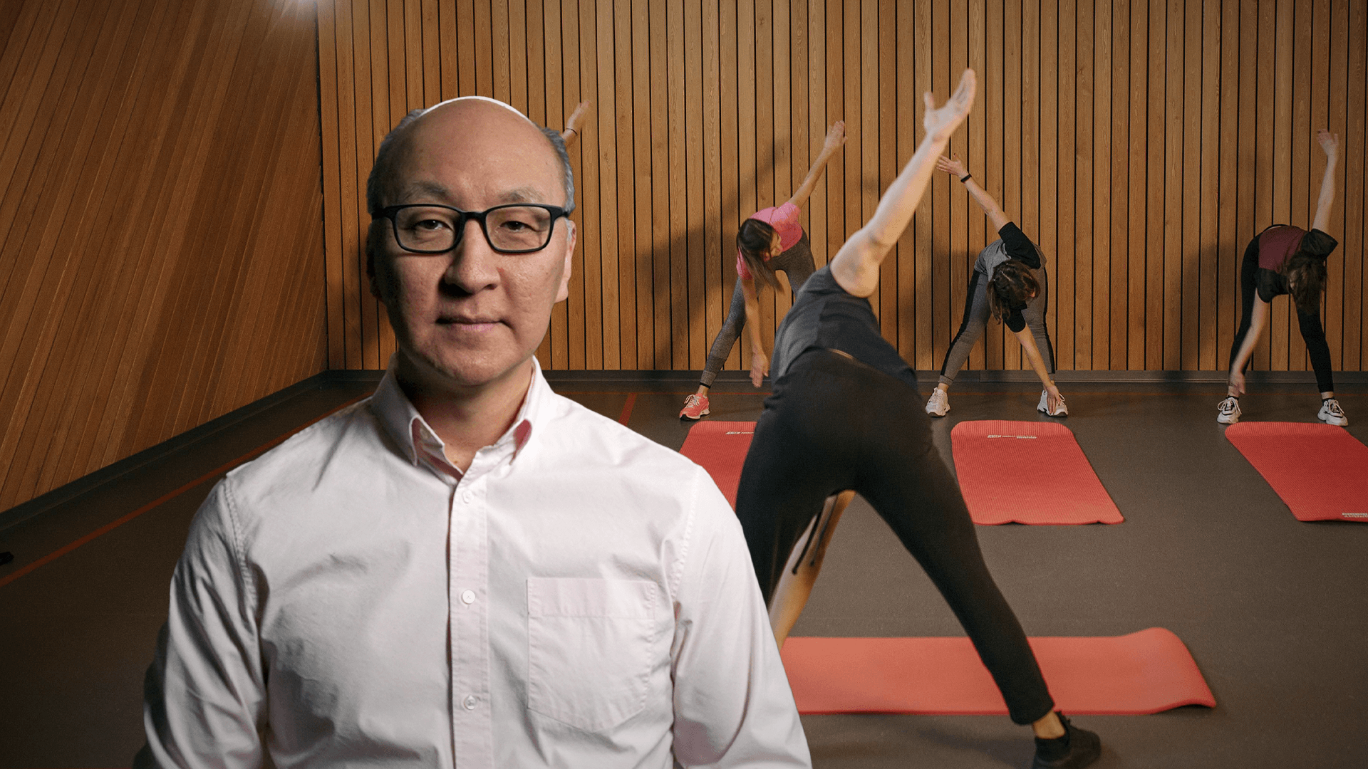 Insoo Hyun in front of an image of a yoga class