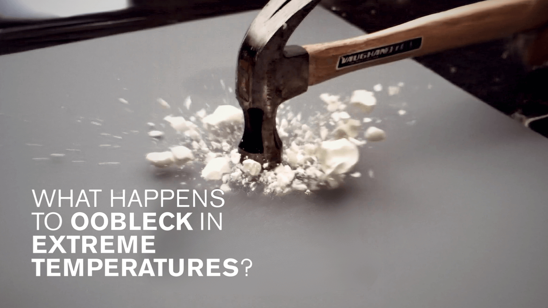 A hammer hitting and shattering frozen oobleck with the white text saying "What happens to oobleck in extreme temperatures?"
