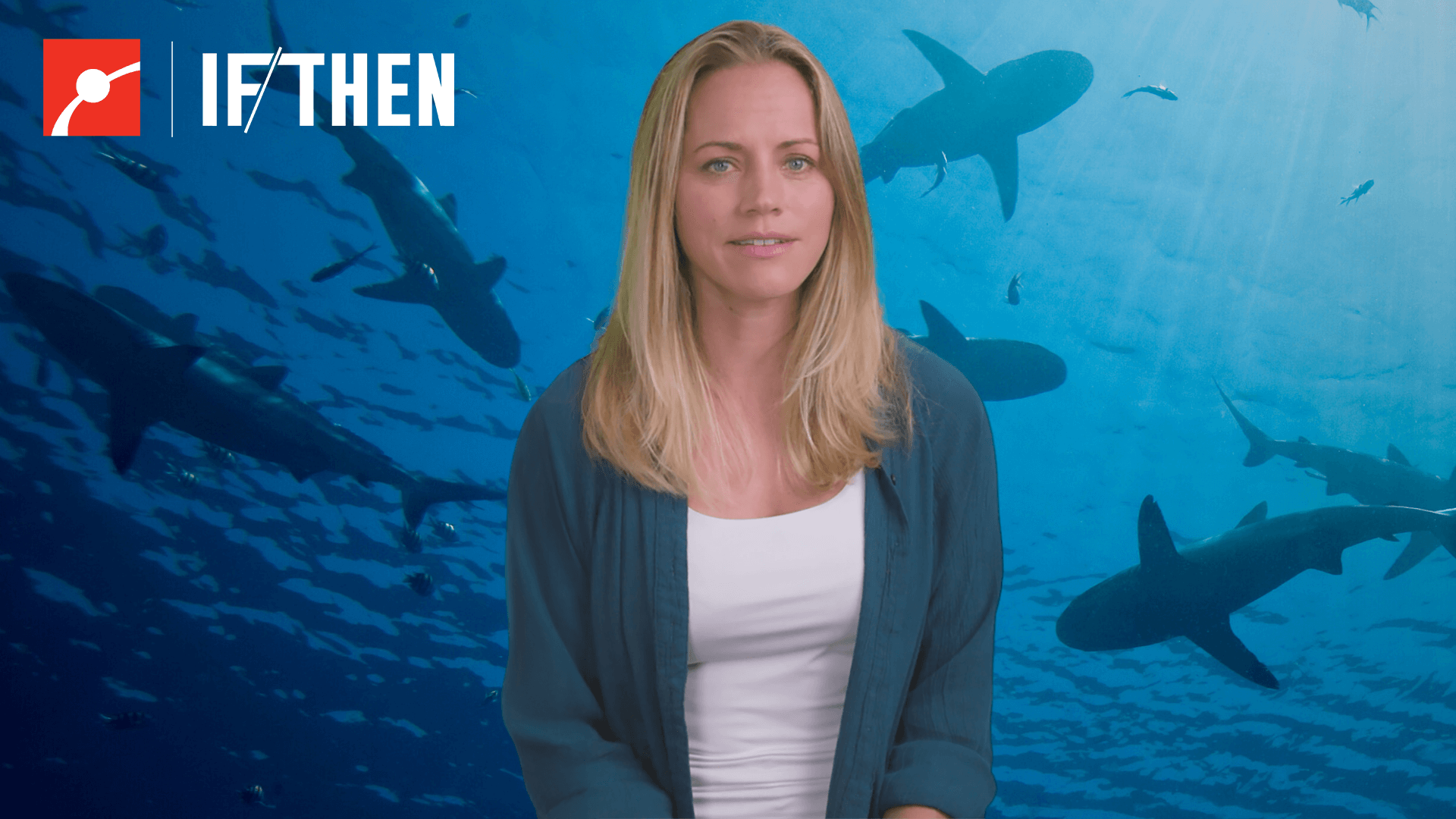 Jess Cramp in front of an underwater view of sharks