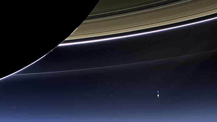 The image known as the The Day the Earth Smiled shows Earth (and the Moon) visible as a bright dot under the rings at lower right. Credit: NASA/JPL/SSI