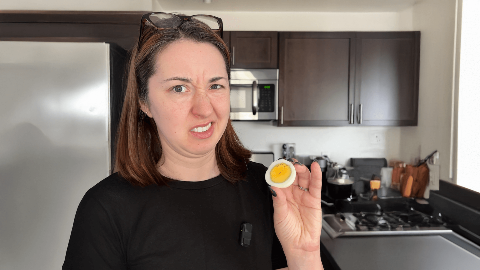 Alex Dainis making a face while holding a hardboiled egg.
